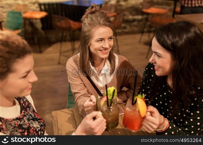 leisure, celebration, party, people and holidays concept - happy friends clinking drinks at restaurant. happy friends clinking drinks at restaurant