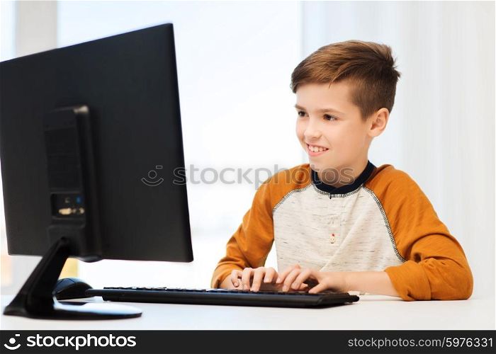 leisure, children, education, technology and people concept - smiling boy with computer at home