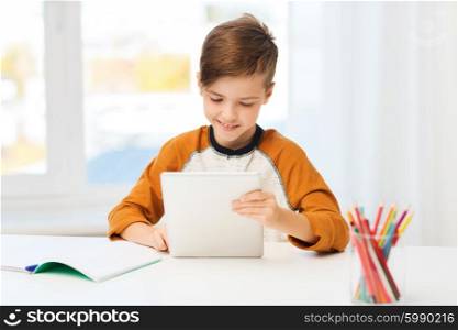 leisure, children, education, technology and people concept - smiling boy with tablet pc computer and notebook at home