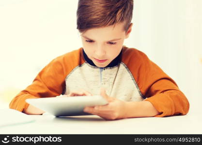 leisure, children, technology and people concept - close up of boy with tablet pc computer at home. close up of boy with tablet pc computer at home