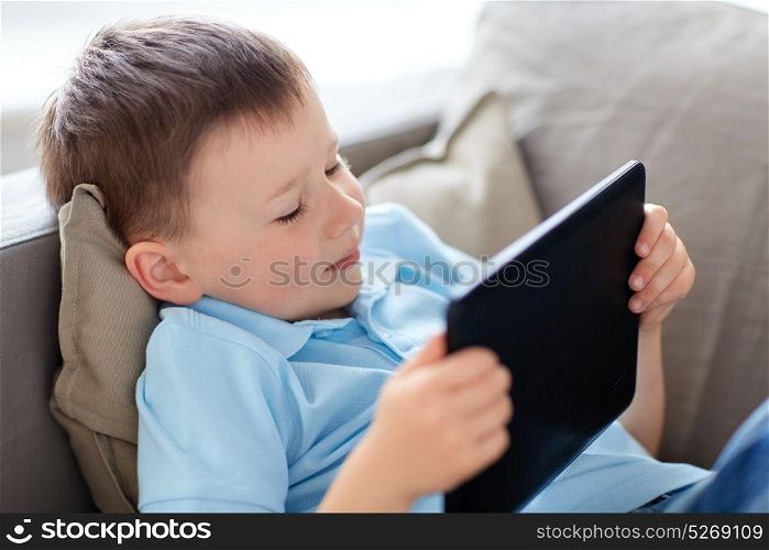 leisure, children, technology and people concept - little boy with tablet pc computer at home. little boy with tablet pc computer at home