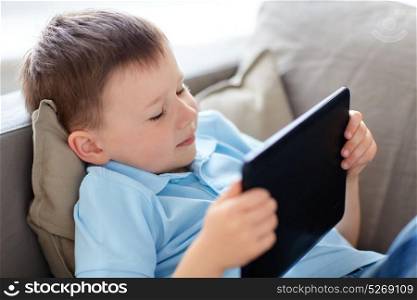 leisure, children, technology and people concept - little boy with tablet pc computer at home. little boy with tablet pc computer at home