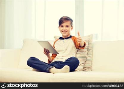 leisure, children, technology and people concept - smiling boy with tablet pc computer showing thumbs up at home. smiling boy with tablet showing thumbs up at home