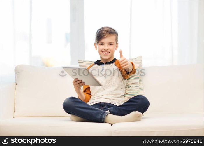 leisure, children, technology and people concept - smiling boy with tablet pc computer showing thumbs up at home