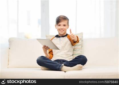 leisure, children, technology and people concept - smiling boy with tablet pc computer showing thumbs up at home