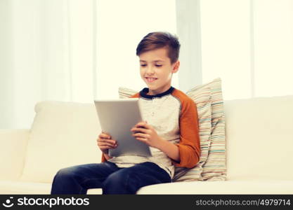 leisure, children, technology and people concept - smiling boy with tablet pc computer at home. smiling boy with tablet computer at home