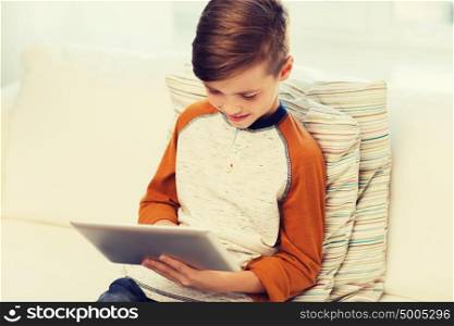 leisure, children, technology and people concept - smiling boy with tablet pc computer at home. smiling boy with tablet computer at home