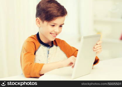 leisure, children, technology and people concept - smiling boy with tablet pc computer at home. smiling boy with tablet pc computer at home