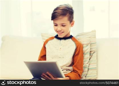 leisure, children, technology and people concept - smiling boy with tablet pc computer at home. smiling boy with tablet computer at home