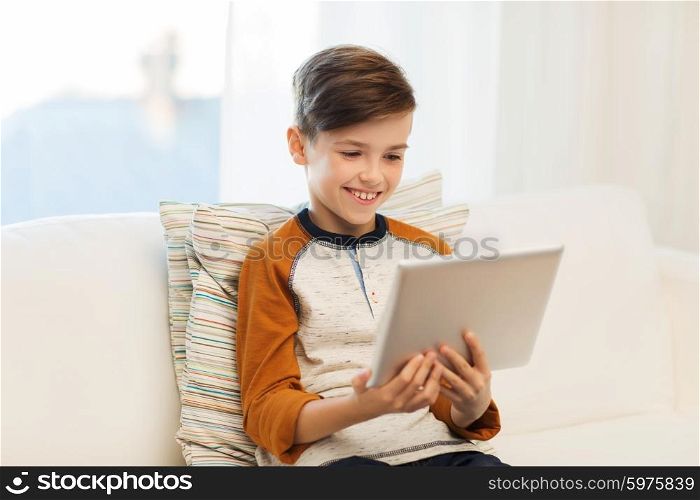 leisure, children, technology and people concept - smiling boy with tablet pc computer at home
