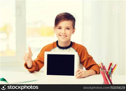 leisure, children, technology, education and people concept - smiling boy showing empty tablet pc computer screen and showing thumbs up at home. happy boy with tablet pc showing thumbs up at home