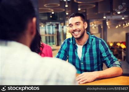 leisure, communication and people concept - happy smiling man meeting with friends at restaurant. happy man meeting with friends at restaurant