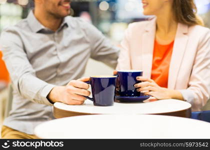 leisure, communication, relations and people concept - close up of happy couple drinking coffee in mall