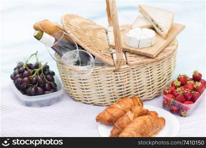leisure concept - picnic basket, food and wine glasses on blanket. picnic basket, food and wine glasses on blanket