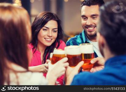 leisure, drinks, celebration, people and holidays concept - smiling friends drinking beer and clinking glasses at restaurant or pub. friends drinking beer and clinking glasses at pub