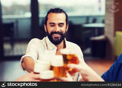 leisure, drinks, celebration, people and holidays concept - smiling man clinking beer glass with friends at restaurant. man clinking beer glass with friends at restaurant