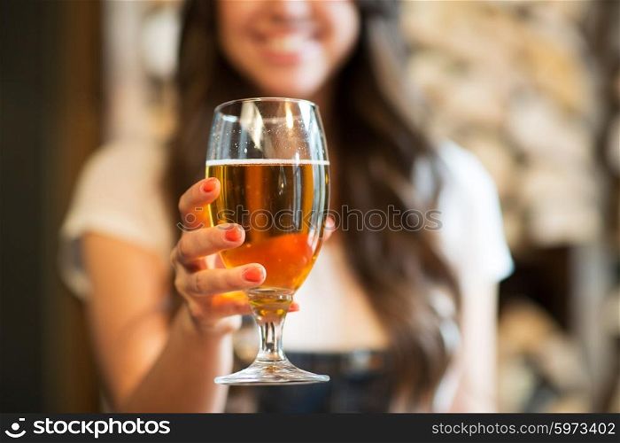 leisure, drinks, degustation, people and holidays concept - close up of smiling woman hand holding glass of draft lager beer
