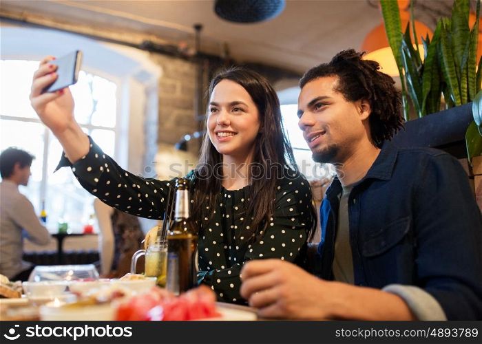 leisure, eating, food and drinks, people and holidays concept - happy couple with drinks at cafe or bar