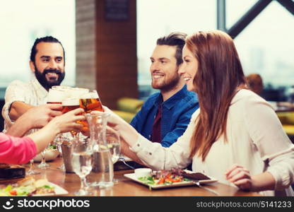 leisure, eating, food and drinks, people and holidays concept - smiling friends having dinner and drinking beer at restaurant or pub. friends dining and drinking beer at restaurant