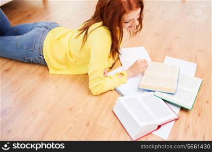 leisure, education and home concept - smiling teenage girl reading books on floor