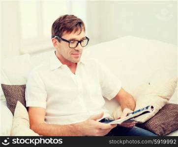 leisure, education and lifestyle concept - man with magazine at home