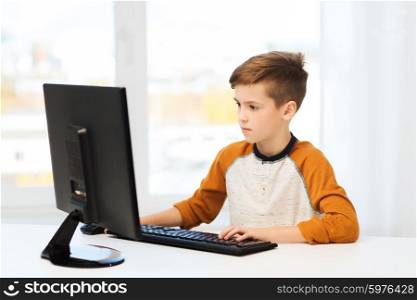 leisure, education, children, technology and people concept - boy with computer at home