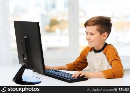 leisure, education, children, technology and people concept - smiling boy with computer at home