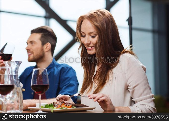 leisure, food and drinks, people and holidays concept - happy couple having dinner at restaurant