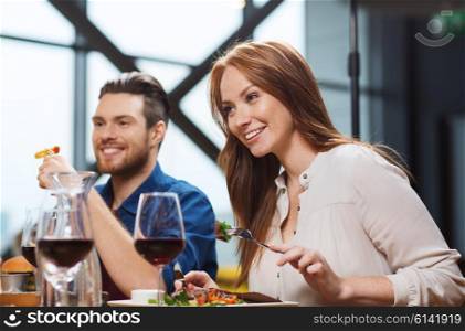 leisure, food and drinks, people and holidays concept - happy couple having dinner at restaurant