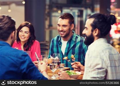 leisure, food and drinks, people and holidays concept - happy friends having dinner at restaurant. happy friends having dinner at restaurant