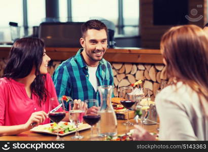 leisure, food and drinks, people and holidays concept - happy friends having dinner at restaurant. happy friends having dinner at restaurant