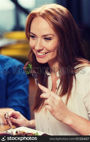 leisure, food and drinks, people and holidays concept - happy woman having dinner at restaurant. happy woman having dinner at restaurant