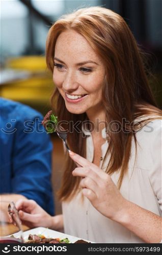 leisure, food and drinks, people and holidays concept - happy woman having dinner at restaurant