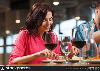 leisure, food and drinks, people and holidays concept - happy woman with friends having dinner at restaurant