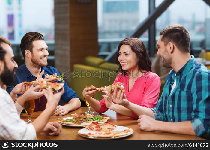 leisure, food and drinks, people and holidays concept - smiling friends eating pizza and drinking beer at restaurant or pub