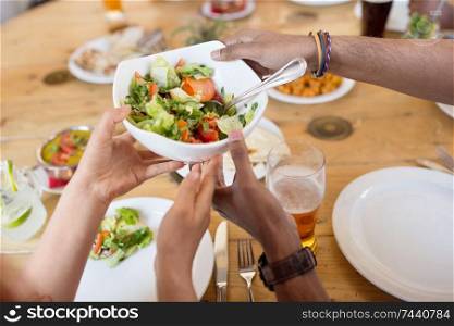 leisure, food and people concept - group of happy international friends eating at restaurant table. international friends eating at restaurant