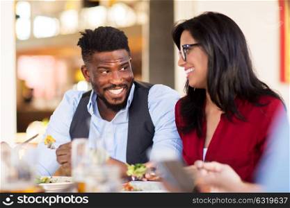 leisure, food and people concept - happy couple eating at restaurant. happy couple eating at restaurant
