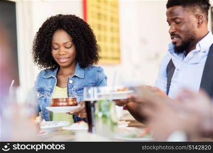 leisure, food and people concept - happy man and woman eating at restaurant. happy man and woman eating at restaurant