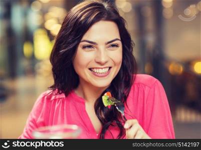 leisure, food, eating, people and holidays concept - happy woman with friends having dinner at restaurant. happy young woman having dinner at restaurant