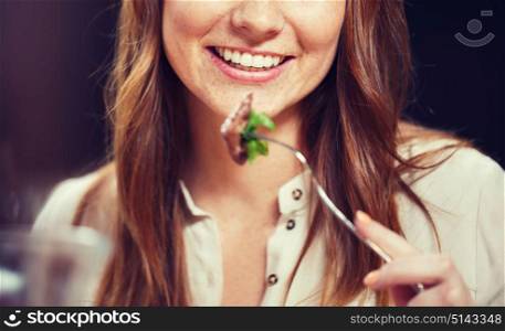 leisure, food, eating, people and holidays concept - happy woman with friends having dinner at restaurant. happy young woman having dinner at restaurant