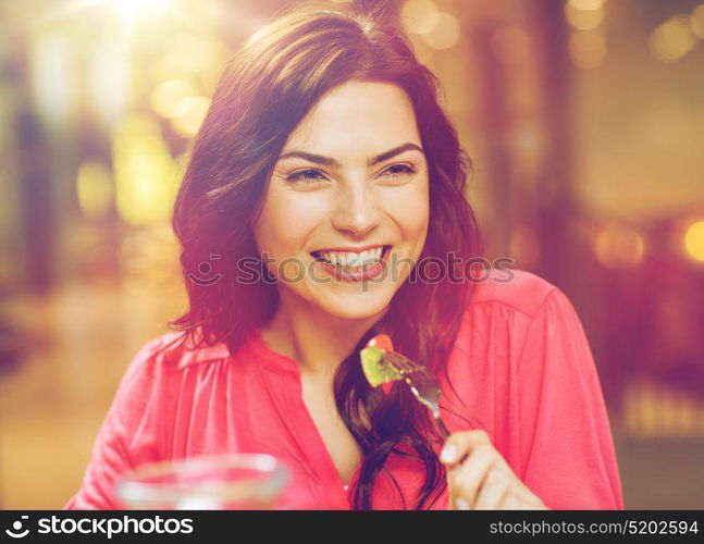 leisure, food, eating, people and holidays concept - happy woman with friends having dinner at restaurant. happy young woman having dinner at restaurant