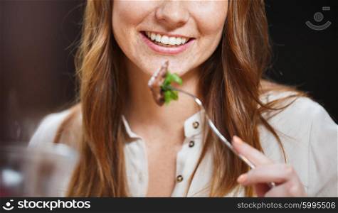 leisure, food, eating, people and holidays concept - happy woman with friends having dinner at restaurant