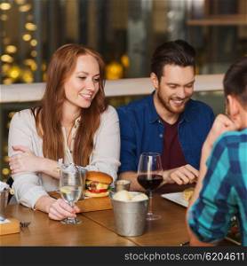 leisure, food, lifestyle and people concept - friends dining at restaurant