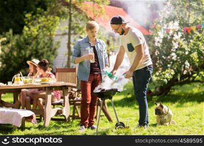 leisure, food, people and holidays concept - friends cooking meat on barbecue grill at summer outdoor party