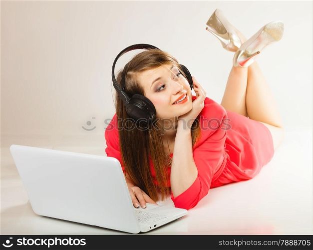 Leisure free time, music, online and internet concept - happy teenage girl with headphones and laptop computer