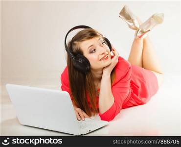 Leisure free time, music, online and internet concept - happy teenage girl with headphones and laptop computer