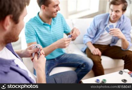 leisure, games, friendship, gambling and entertainment - close up of male friends playing cards at home