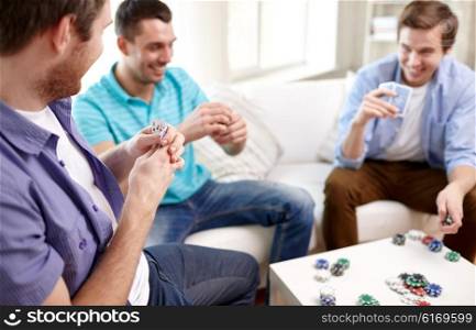 leisure, games, friendship, gambling and entertainment - close up of male friends playing cards at home