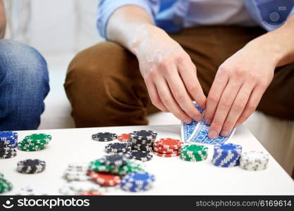 leisure, games, friendship, gambling and entertainment - close up of male hand with playing cards and chips at home