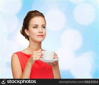 leisure, happiness and drink concept - smiling woman in red dress with cup of coffee over blue lights background